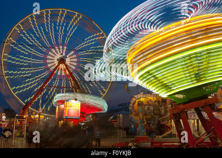 Bunt beleuchtete Fahrgeschäfte drehen gegen den Nachthimmel während der New Jersey State Fair in Augusta im US-Bundesstaat New Jersey. Stockfoto