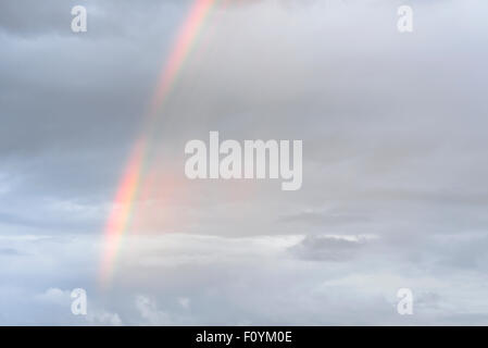 Ein schwaches Regenbogen zeigt sich nach einem Gewitter. Stockfoto