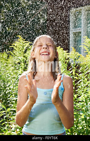 Glückliches Mädchen unter Sommerregen Stockfoto