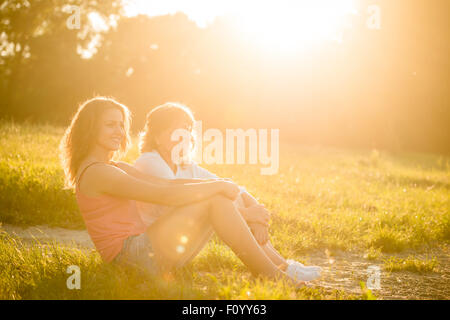 Reife Mutter mit ihrer Tochter am Ufer sitzen und tolle Zeit zusammen Stockfoto