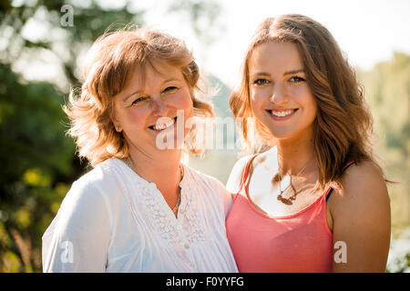 Outdoor Portrait Reife Mutter mit ihrer Tochter im Teenageralter - Hintergrundbeleuchtung mit Sonne Stockfoto