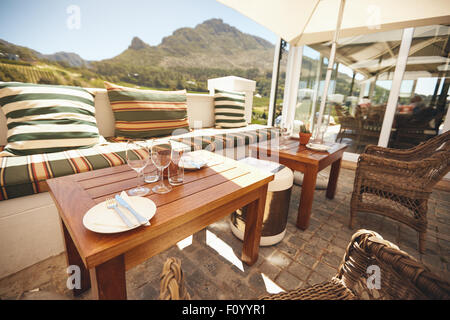 Schuss von schönen Weingut Hof Restaurant.  Tisch in einem Restaurant im Freien mit leeren Wein Gläser und Teller. Stockfoto