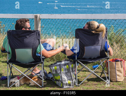 Junges Paar Sitzen entspannen, Hände halten, direkt am Meer, Bournemouth, Dorset, England, Großbritannien Stockfoto