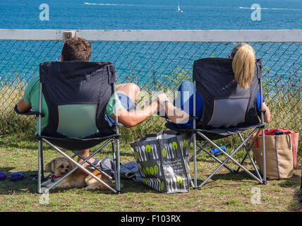Junges Paar Sitzen entspannen, Hände halten, direkt am Meer, Bournemouth, Dorset, England, Großbritannien Stockfoto