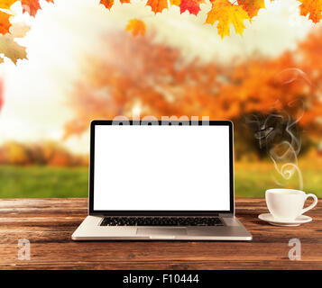 Laptop auf Holztisch im Herbst Stockfoto