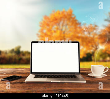 Laptop auf Holztisch im Herbst Stockfoto