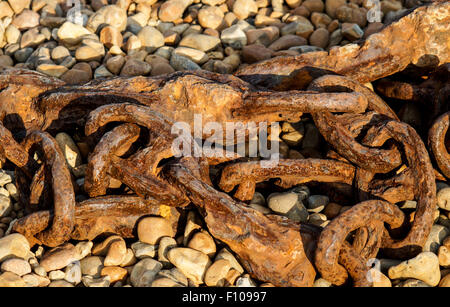 Alte rostige Schiff Kette liegen an einem steinigen Strand Stockfoto