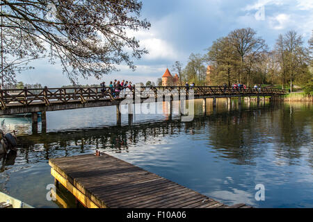 TRAKAI, Litauen - 29. April 2015: Blick auf Holzbrücke auf Galve See mit Reflexion der Wolken auf, um Burg Trakai. Stockfoto