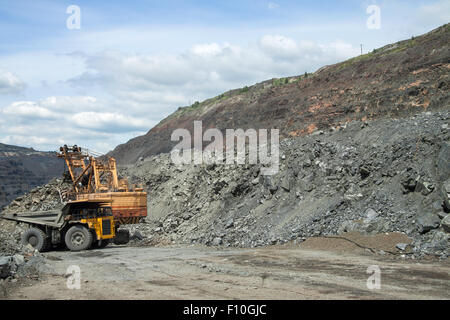 Muldenkipper mit Eisenerz auf den Tagebau geladen wird Stockfoto