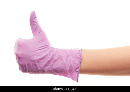 Nahaufnahme eines weiblichen Arzt Hand in lila sterilisierte Operationshandschuh zeigt Daumen hoch Zeichen vor weißem Hintergrund Stockfoto