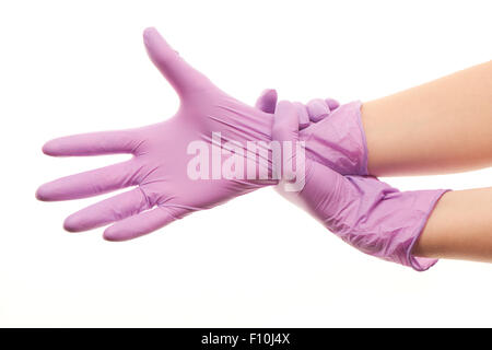 Nahaufnahme eines weiblichen Arzt Hände aufsetzen lila sterilen OP-Handschuhe vor weißem Hintergrund Stockfoto