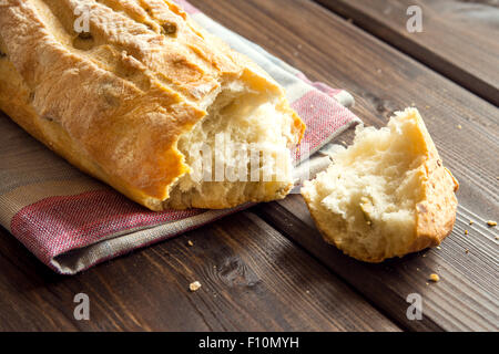 Frisches italienisches Ciabatta Brot mit grünen Oliven auf Holztisch Stockfoto