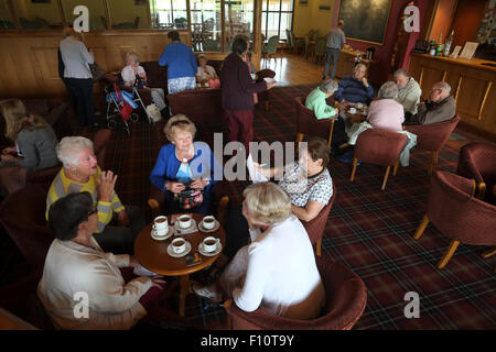 Eine Gruppe von senior reife Männer und Frauen, Rentner alle, Geselligkeit und plaudern über Tee und Kaffee auf ihren regelmäßigen Aberystwyth Freundschaft soziale Fraktionssitzung in einem örtlichen club Stockfoto