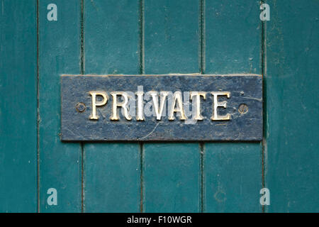 Nahaufnahme eines privaten Zeichens einer alten Holztür grün lackiert Stockfoto