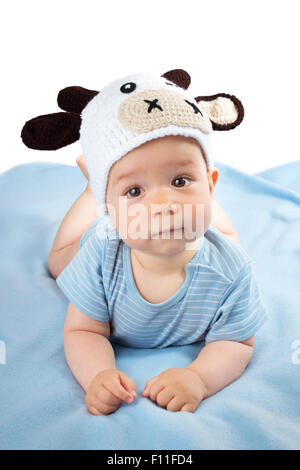 Baby in einem Kuh-Hut auf blaue Decke Stockfoto