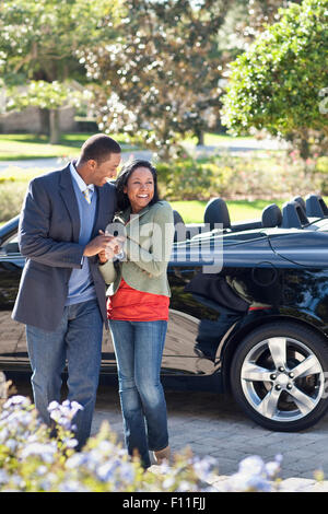 Paare, die in Einfahrt am Cabrio Stockfoto