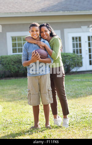 Mutter und Sohn umarmt im Hinterhof Stockfoto