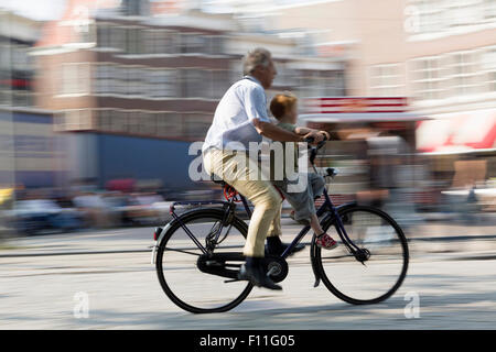 Verschwommene Sicht von Vater und Sohn auf städtische Straße Radfahren Stockfoto
