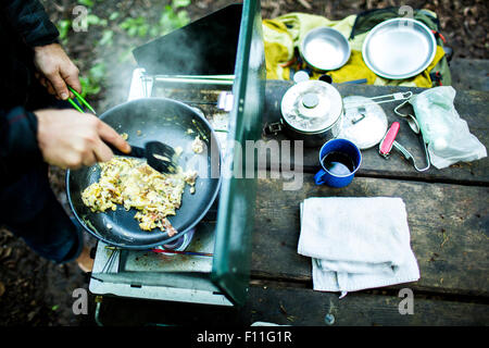 Kaukasischen Mann Kochen von Eiern auf Campingplatz Stockfoto