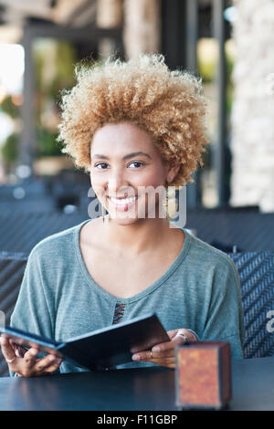 Schwarze Frau Menü im Café lesen Stockfoto