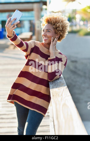 Schwarze Frau unter Selfie auf Holzsteg Stockfoto