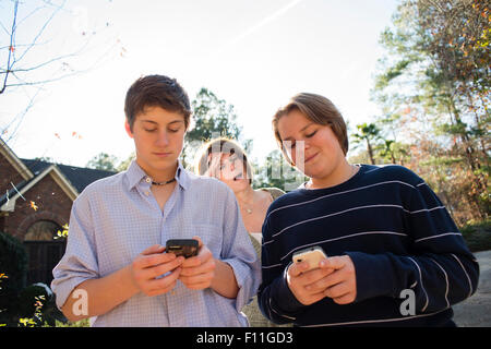 Frustriert kaukasischen Mutter beobachtete Söhne nutzen Handys Stockfoto