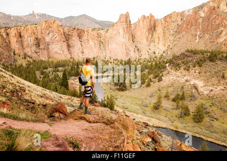 Kaukasische Wanderer bewundernden Hügel und Stream in Wüstenlandschaft, Smith Rock State Park, Oregon, Vereinigte Staaten von Amerika Stockfoto