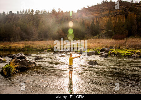 Kaukasischen Mann Angeln in abgelegenen Fluss, Smith Rock State Park, Oregon, Vereinigte Staaten von Amerika