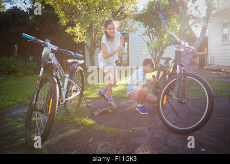 Gemischte Rassen Kinder Befestigung Fahrräder im Hinterhof Stockfoto