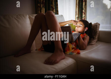 Gemischte Rassen Mädchen mit digital-Tablette auf sofa Stockfoto