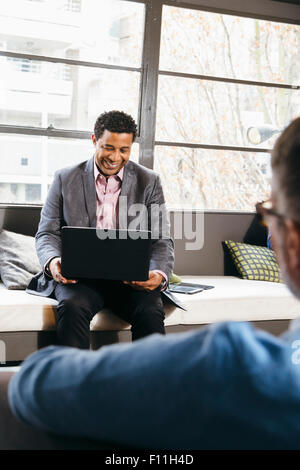 Geschäftsleute, die mit Laptop im Büro lobby Stockfoto