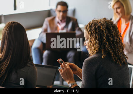 Geschäftsfrau mit Handy im Büro treffen Stockfoto