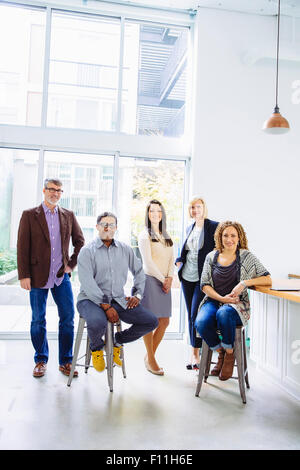 Geschäftsleute, die lächelnd im Büro Stockfoto