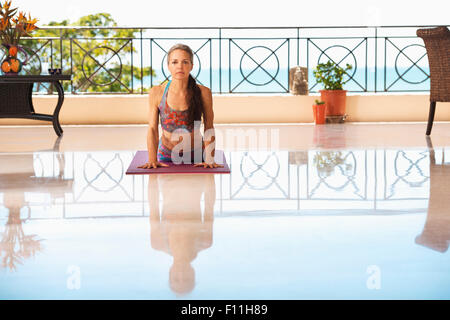 Hispanic Frau praktizieren Yoga auf Balkon Stockfoto