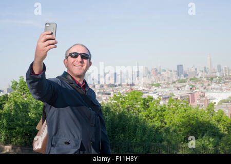 Hispanic Mann unter Selfie mit Stadtbild von New York, New York, Vereinigte Staaten von Amerika Stockfoto