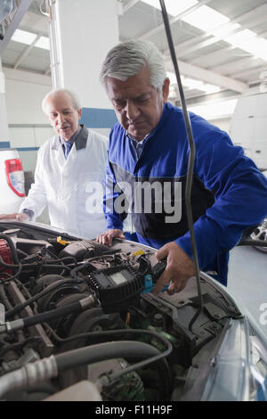 Ältere Hispanic Mechanik Reparatur Auto in garage Stockfoto