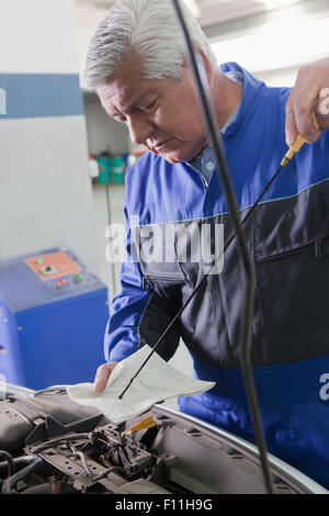 Ältere Hispanic Mechaniker reparieren Auto in garage Stockfoto