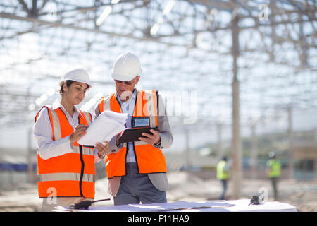 Architekten, die Baupläne auf Baustelle lesen Stockfoto