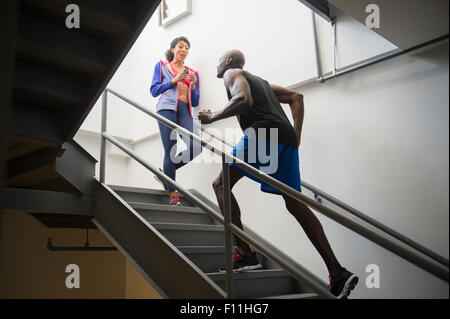 Mann läuft mit Trainer auf Treppe Stockfoto