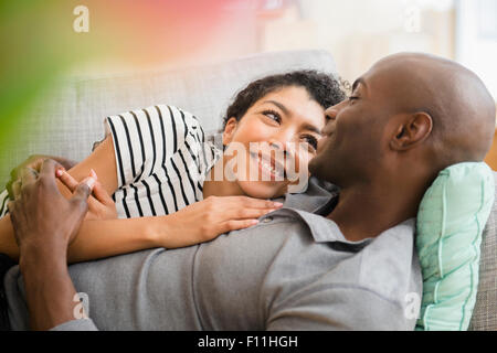 Lächelnde paar Verlegung auf sofa Stockfoto