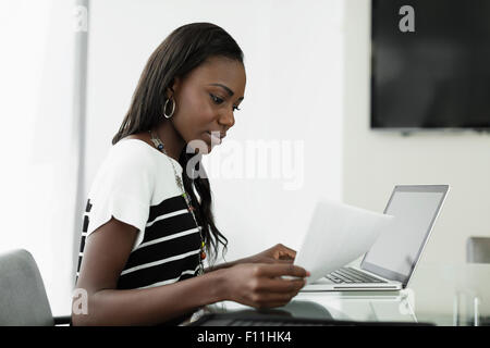 Geschäftsfrau Notenlesen am Schreibtisch Stockfoto