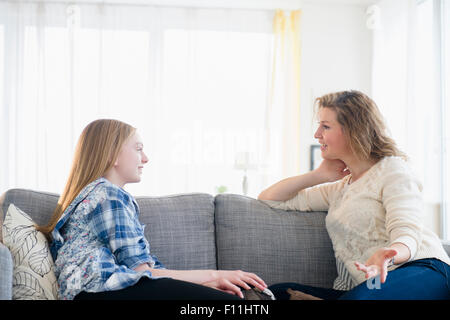 Kaukasische Mutter und Tochter sprechen auf sofa Stockfoto