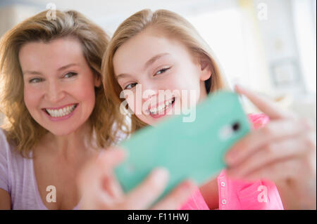 Kaukasische Mutter und Tochter unter Selfies mit Handy Stockfoto