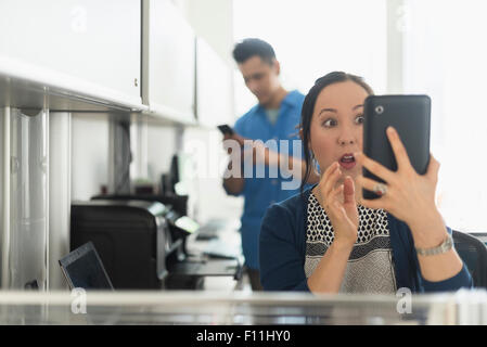 Überrascht, Geschäftsfrau, die mit digital-Tablette in office Stockfoto