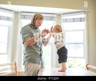 Kaukasische Vater Sohn auf Tisch stehen Lehre Stockfoto