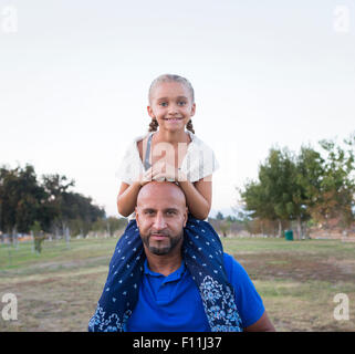 Vater mit Tochter auf Schultern im park Stockfoto