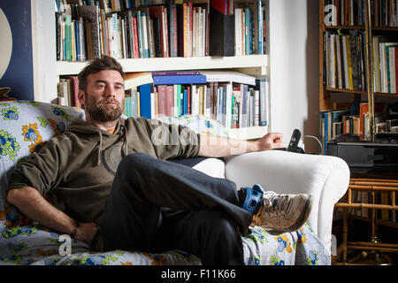 Kaukasischen Mann sitzt auf der Couch im Wohnzimmer Stockfoto