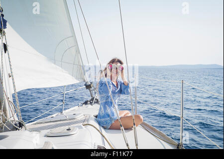 Kaukasische Frau mit dem Fernglas auf Bootsdeck Stockfoto