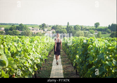 Kaukasische Frau zu Fuß auf Holzsteg im Weinberg Stockfoto