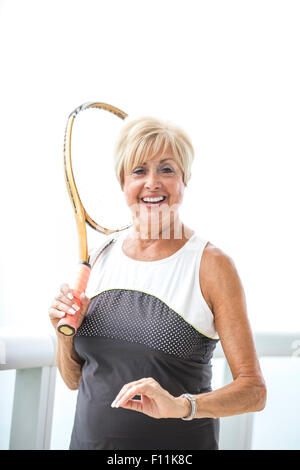 Ältere Frau kaukasischen holding Tennisschläger auf Balkon Stockfoto